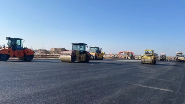 近日，在西部市政建設(shè)集團(tuán)蘭州新區(qū)城市礦產(chǎn)與表面處理產(chǎn)業(yè)園區(qū)（二期）周邊基礎(chǔ)設(shè)施項(xiàng)目—園區(qū)西路南延段（緯五十路至緯二十八路）項(xiàng)目現(xiàn)場(chǎng)，隨著一輛輛運(yùn)料車(chē)平穩(wěn)駛?cè)?，攤鋪機(jī)將滾燙的瀝青混合料均勻鋪開(kāi)，標(biāo)志著項(xiàng)